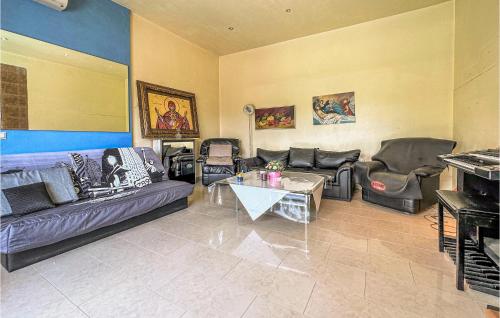 a living room with couches and a table at 3 Bedroom Cozy Home In Koropi in Áyios Nikólaos