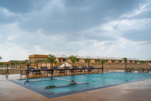 a pool at a resort with chairs and tents at Marugarh Camp and Resort Jaisalmer in Jaisalmer