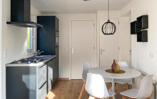 a kitchen with a white table and a table and chairs at 2 Bedroom Cozy Home In Heinkenszand in Heinkensand