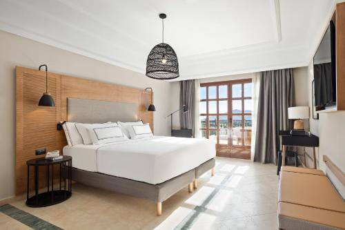 a bedroom with a large white bed and a window at The Level at Meliá Villaitana in Benidorm