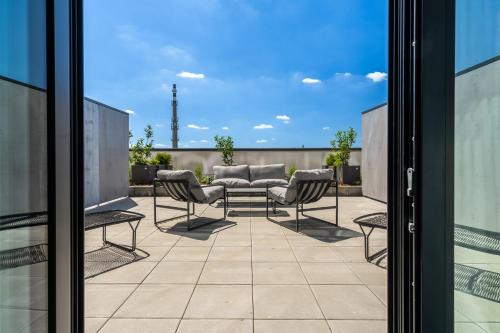 a patio with a table and chairs on a balcony at HONEST Ricany in Ricany