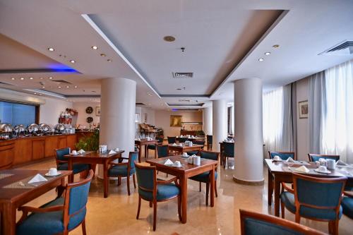 a restaurant with tables and chairs and a bar at Swiss Inn Nile Hotel in Cairo