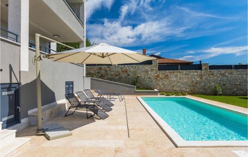 una piscina con 2 sillas y una sombrilla junto a una casa en Villa Nebra, en Frata