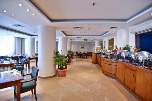 a restaurant with a bar and some tables and chairs at Swiss Inn Nile Hotel in Cairo