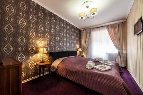 a bedroom with a bed with a red bedspread at Готель Ольга in Tatariv
