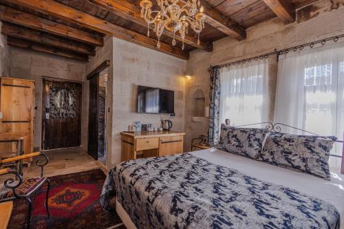 a bedroom with a bed and a chandelier at Göreme Cave Suites in Goreme