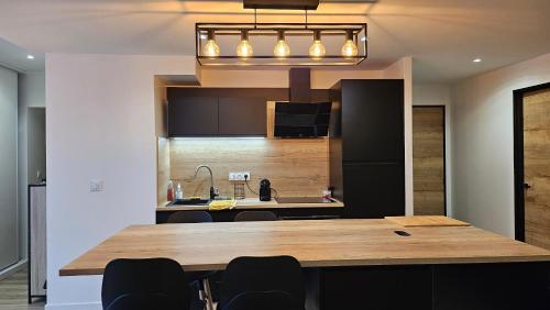 une cuisine avec une grande table et des chaises en bois dans l'établissement Appartement cozy 2 chambres, à Luchon