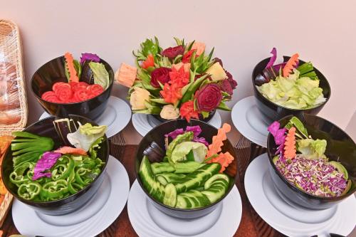 a group of bowls filled with vegetables on plates at Swiss Inn Nile Hotel in Cairo