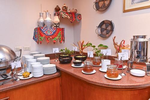 a kitchen counter with plates and dishes on it at Swiss Inn Nile Hotel in Cairo