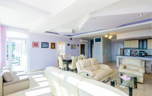 a living room with white furniture and a kitchen at Cozy Apartment In Dubravka With Sauna in Gruda