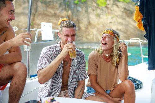 a man and woman sitting on a boat drinking beer at Lagoon Attitude (Adults Only) in Cap Malheureux