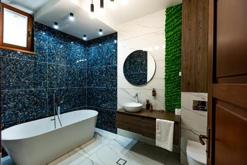 a bathroom with a tub and a green wall at Wanderer Sighisoara in Sighişoara