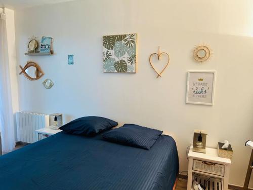 - une chambre avec un lit bleu et un cœur sur le mur dans l'établissement La Seigneurerie Le Grand Studio, à Deauville