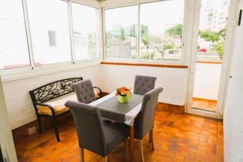 une table et des chaises dans une pièce avec des fenêtres dans l'établissement Le Bridge Barcarès Clim Accès plage direct Parking Privé, au Barcarès