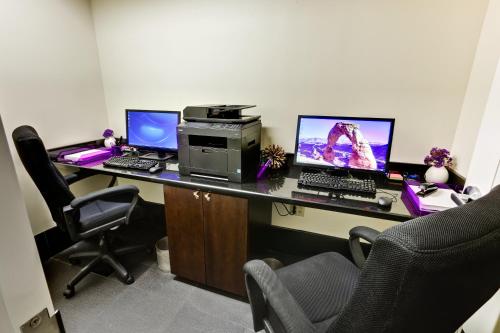 an office with two computers and a printer on a desk at Hotel Le Marais in New Orleans