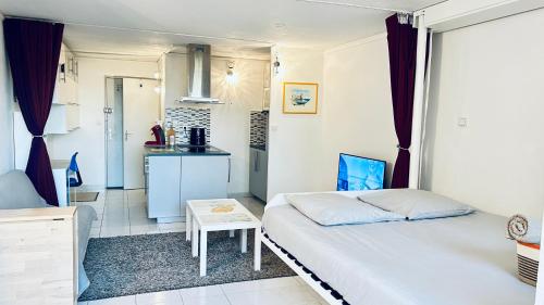 une petite chambre avec un lit et une table dans l'établissement Studio Confort l'Escapade du Port, à Gruissan