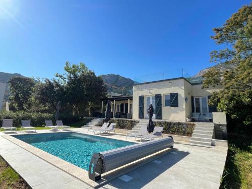 une piscine avec des chaises et une maison dans l'établissement Villa de standing, à Calvi