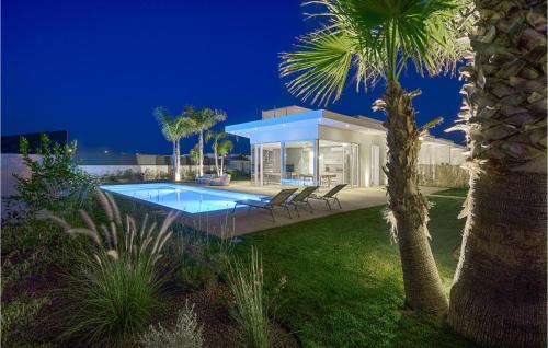 a house with a swimming pool and a palm tree at Villa Limone in Marina di Ragusa