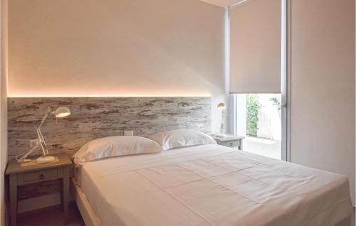 a bedroom with a large white bed and a window at Villa Limone in Marina di Ragusa
