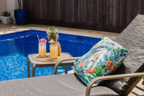 two drinks on a table next to a pool at Tropical 2 BR, 2 Bath Villa with private pool in Palm Cove