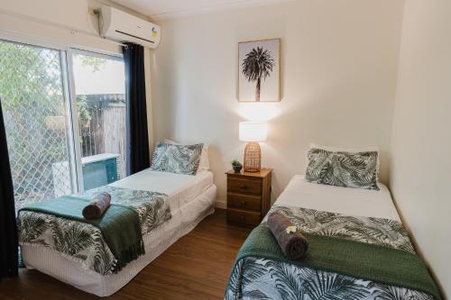 a bedroom with two beds and a window at Tropical 2 BR, 2 Bath Villa with private pool in Palm Cove