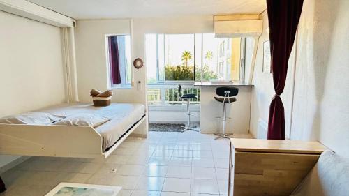 une chambre avec un lit et une grande fenêtre dans l'établissement Studio Confort l'Escapade du Port, à Gruissan