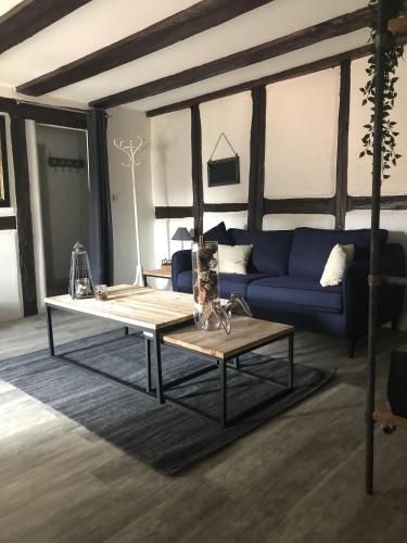a living room with a blue couch and a coffee table at Sous les toits du Zinc - Climatisé in Colmar