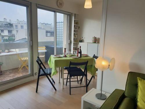 une salle à manger avec une table et des chaises vertes dans l'établissement Alesia - Plantes, à Paris