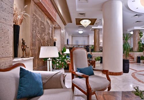 a lobby with a couch and chairs in a building at Swiss Inn Nile Hotel in Cairo