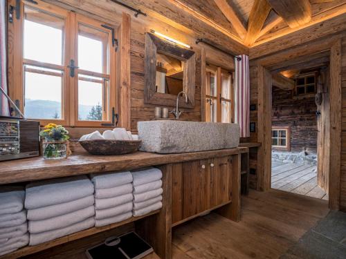 ein Badezimmer mit einem Waschbecken in einer Blockhütte in der Unterkunft Buccara Zwischenbachalm in Westendorf