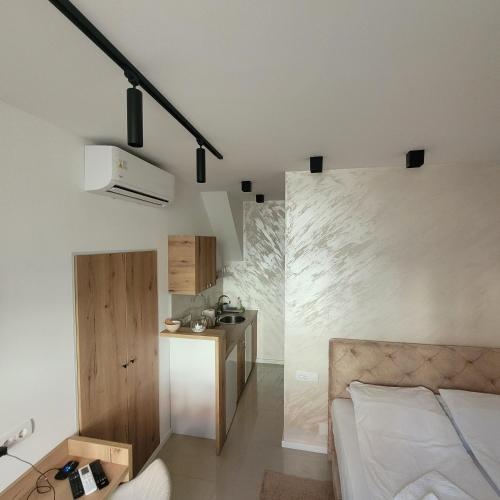 a bedroom with a bed and a small kitchen at Dream House in Novi Sad