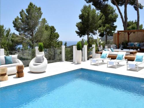 a pool with chaise lounge chairs and a swimming pool at Villa in Ibiza with Sea Views and Jacuzzi in Es Cubells