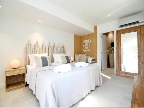 a bedroom with two beds with white sheets at Villa in Ibiza with Sea Views and Jacuzzi in Es Cubells