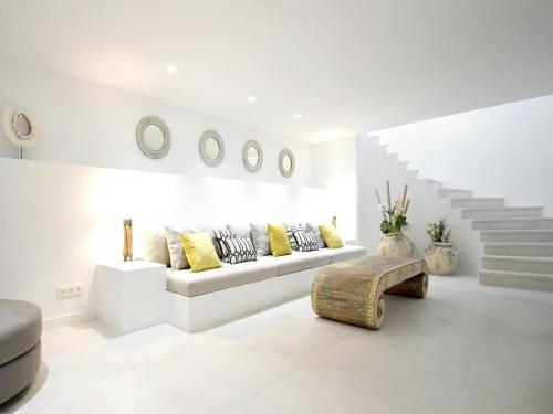 a white living room with a couch and stairs at Villa in Ibiza with Sea Views and Jacuzzi in Es Cubells