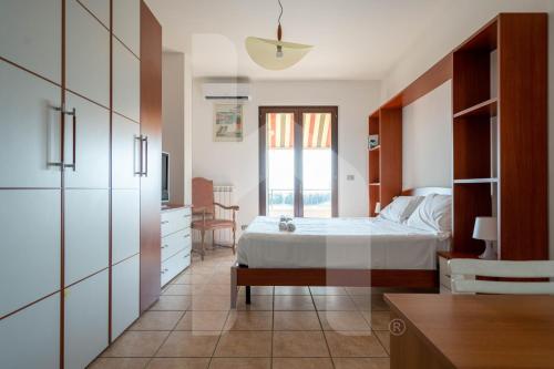 a bedroom with a bed and a desk and a tv at Homiday - Villa Mila in Pineto