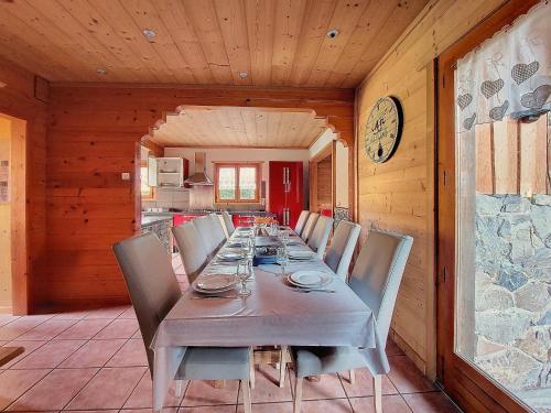 une salle à manger avec une table, des chaises et une horloge dans l'établissement Manupa, à Morzine