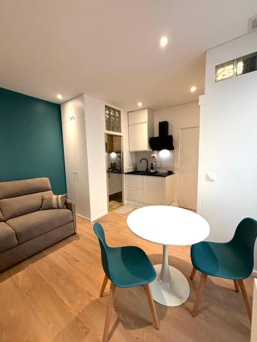 un salon avec une table, des chaises et un canapé dans l'établissement Studio Cosy Montmartre, à Paris