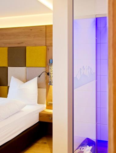 a bedroom with a bed and a glass door at Sporthotel Ellmau in Tirol in Ellmau