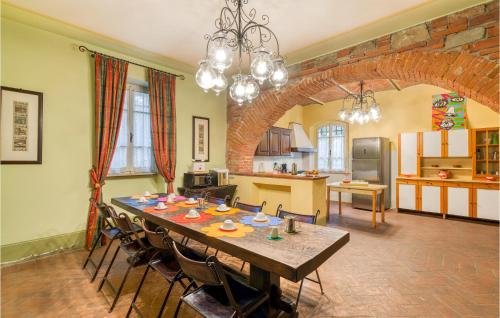 a dining room with a table and a kitchen at Villa Pieve, Lucignano in Lucignano