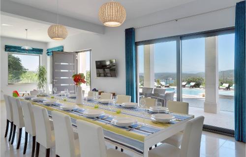 a dining room with a long table and white chairs at Villa Rachele in Pula