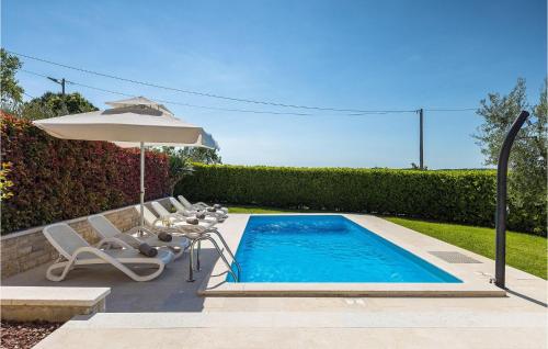 a swimming pool with an umbrella and two chairs and an umbrella at Villa Marasi in Poreč