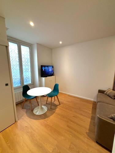 un salon avec une table, des chaises et un canapé dans l'établissement Studio Cosy Montmartre, à Paris