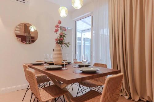 - une table à manger avec des chaises et un vase fleuri dans l'établissement Angleterre 3 - Nice Centre - 3 pièces 2 SDB, à Nice