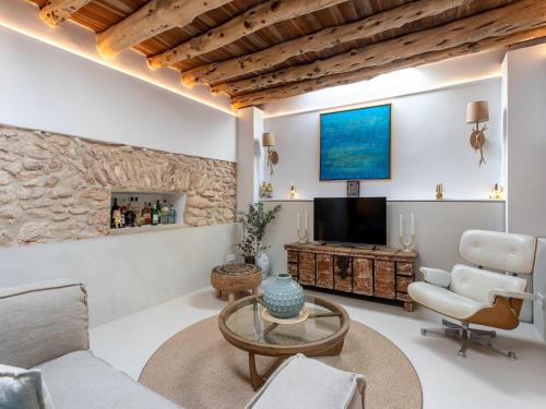 a living room with a couch and a tv at Farmhouse in Ibiza with Saltwater Pool in Puig D’en Valls