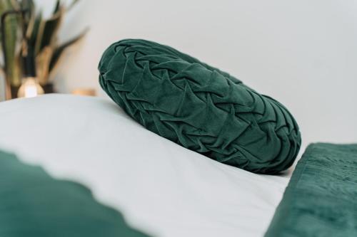 a green pillow sitting on top of a bed at ZILTE STILTE in Ostend