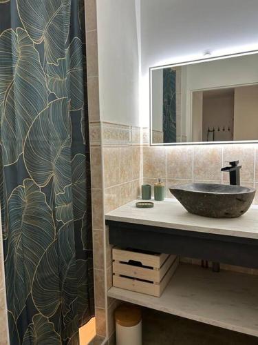 un baño con lavabo y espejo en Maison de ville plein centre, en Saint-Céré