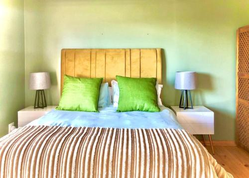 a bedroom with a large bed with green pillows at Seaside Retreat in Kenton-on-Sea in Kenton on Sea