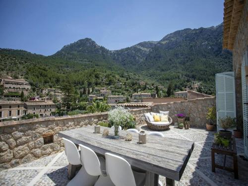 a wooden table and chairs on a patio with mountains at Townhouse in Deia with Sea and Mountain Views in Deia
