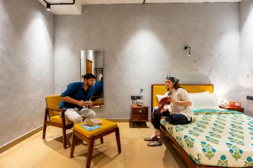 a man and a woman sitting in a bedroom at Local Lok in Varanasi