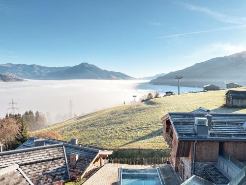 a house with a view of a hill with a pool at CHALET VILLAGE ZAGLGUT Wellness & Views with Summer Card Included in Kaprun